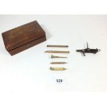 A small brown leather box with contents of five gilt metal pencils etc
