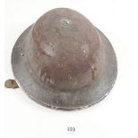 A WW2 British brodie helmet etched to the side with decoration of a bomb