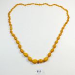 A yellow amber bead necklace, 82gm, largest bead 2.5cm long