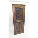 A reproduction oak lead glazed corner cabinet