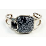 A heavy modernist silver bangle set with black speckled stone