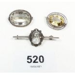 Three silver/white metal brooches set glass