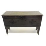 A small 17th century oak coffer raised on split end supports and of single plank construction, the