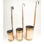 A set of three graduated copper milk measures with brass collars