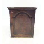 An 18th century oak spice cupboard, the panelled door enclosed four drawers and pigeon holes, 54 x