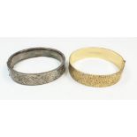 A silver hinged bangle and a rolled gold one
