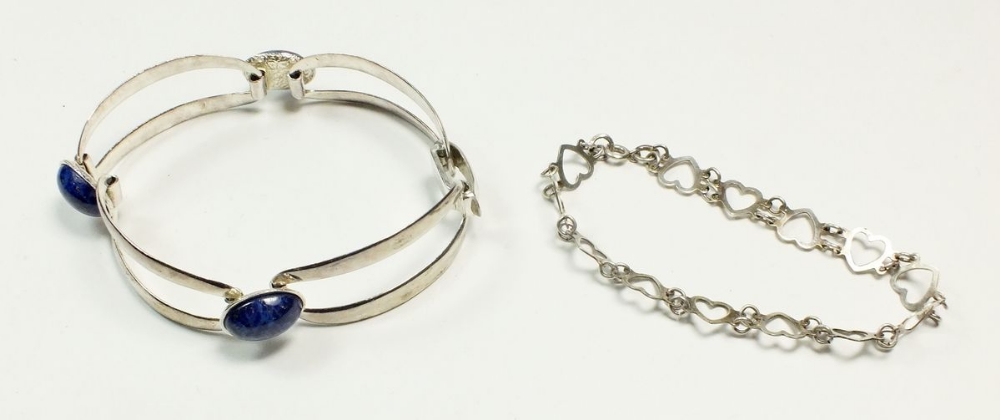 A silver and lapis lazuli bracelet together with a silver heart bracelet