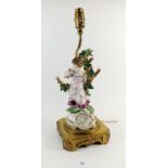 A Spanish porcelain table lamp in form of a girl with bocage on gilt metal base, total height, 42cm,