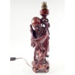 A carved wood oriental table lamp in form of figure of a man