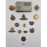 A small selection of miscellaneous vintage military cap badges etc