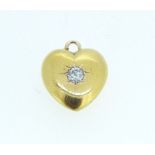 A small 15ct gold heart form pendant set diamond, 1cm x 7mm