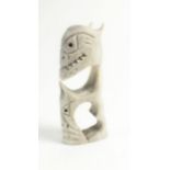 A Russian Inuit carved bone group of a demon, 5.5cm