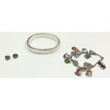 A heavy silver hinged bangle 43g , a silver bracelet with enamel souvenir charms and a pair of