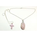A large silver mounted rose quartz pendant and chain and a silver and pink paste crucifix and chain