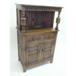 A 20th century Reprodux small sized carved court cupboard, 132cm high x 81cm wide x 45cm deep