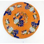 A large Mason's Ironstone charger painted birds and flowers on a coral red ground, 42cm diameter