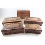 Four Indian carved wooden boxes together with a letter rack