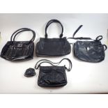 Four large black leather handbags
