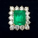 A large emerald and diamond ring, the large emerald (approx 5 cts) within rectangular diamond