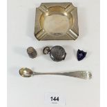 A silver ashtray - 74g, a silver thimble, a white metal olive spoon, a metal sovereign case and a