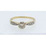 An 18ct gold and platinum set diamond ring, the central stone 1/2ct on diamond set shoulders, size