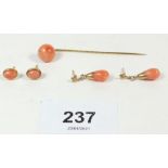 A yellow metal coral set stick pin and two pairs of yellow metal and coral earrings