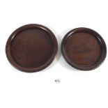 A pair of turned mahogany bottle coasters