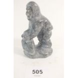 An Inuit grey stone carving of a man working on stone, signed DK from Nuuk in Greenland, 11cm