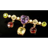 A gold brooch set coloured stones and pearls including heart cut amethyst, peridot and crystal