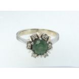 A 14 carat white gold ring set emerald within diamond surround, size O