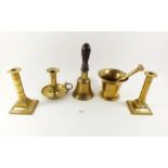 A brass handbell, chamber stick, pair of Georgian candlesticks and a pestle and mortar