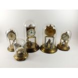 A selection of skeleton clocks in glass domes, tallest 31cm