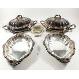A pair of heavy silver plated entree dishes with lids and a pair of vegetable dishes and a silver