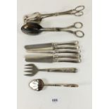 A set of six silver handled tea knives, a silver plated cake fork and three pairs of cake tongs