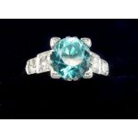 A 1930's Art Deco 18 ct gold and platinum set ring set blue zircon flanked by four diamonds, size