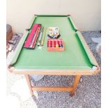 A Riley folding half size snooker table with two Riley cues and various snooker and pool balls