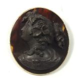 A tortoiseshell and 9 carat gold brooch or pendant with applied carved jet cameo bust of classical