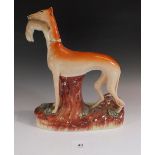 A 19thC Staffordshire figure of a greyhound with hare in mouth, 28cm