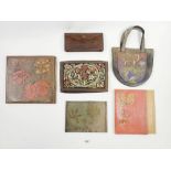 An interesting group of antique Arts and Crafts leather bags and wallets with embossed decoration