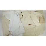 An Edwardian knitted babies bonnet, an embroidered table linen, Victorian chemise, silk babies dress