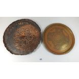 An Arts & Crafts copper embossed tray 31.5 cm diameter and another tray embossed animals