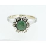 A 14 carat white gold ring set emerald within diamond surround, size O