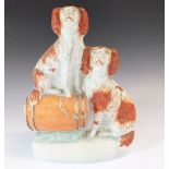 A 19thC Staffordshire pottery figural group of two Spaniels and a a cask, 21.5cm