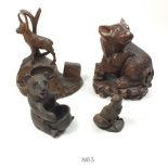 Three carved wooden animal figures including a Black Forest bear plus a metal fox (largest 12.5cm)