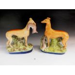 A pair of 19thC Staffordshire greyhound or whippet figures, one with hare in mouth, 26cm