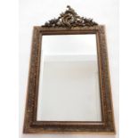 A large gilt framed mirror with moulded floral and foliage frame and scrollwork surmount - 120 x