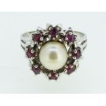 A 14 carat white gold ring set pearl within rubies, size P