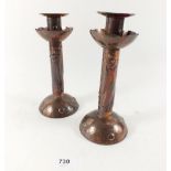 A pair of Newlyn copper candlesticks embossed fish decoration, stamped 'Newlyn' to base, 21cm