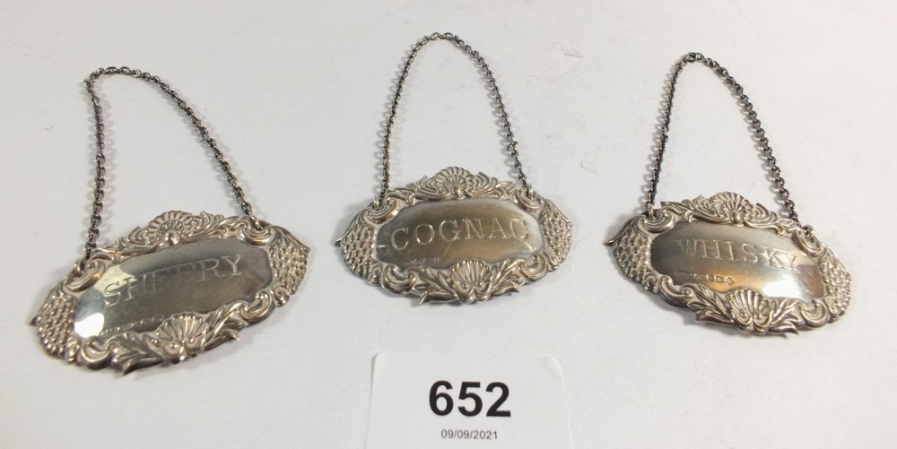 Three silver spirit labels inscribed 'Whisky', 'Cognac' and 'Sherry'