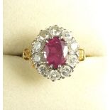 An 18 carat gold round brilliant cut diamond and ruby cluster ring, estimated diamond weight